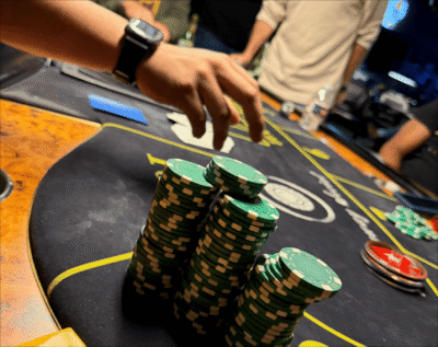 Stack of green poker chips and hand.